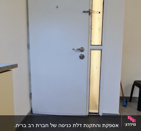 דלת לבנה עם ידית מתכת וחלון צר